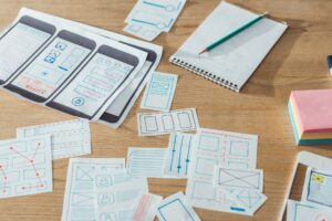 Selective focus of mobile website sketches and layouts on wooden table